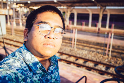 Portrait of mid adult man looking away at railroad station