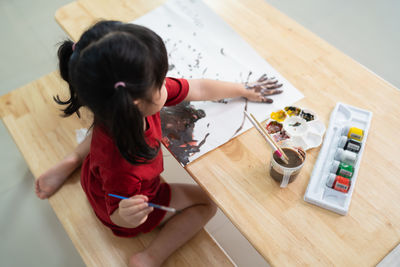 High angle view of girl drawing on table