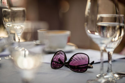 Close-up of wine glass and sunglasses on table