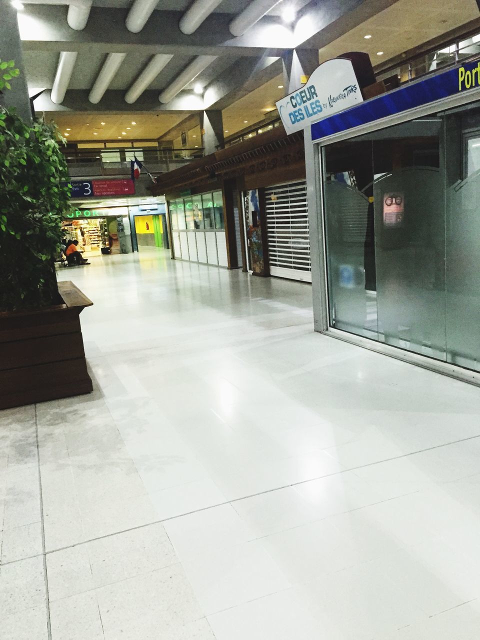 indoors, empty, built structure, architecture, flooring, transportation, illuminated, absence, ceiling, tiled floor, public transportation, incidental people, interior, railroad station, travel, railroad station platform, modern, no people, door, reflection