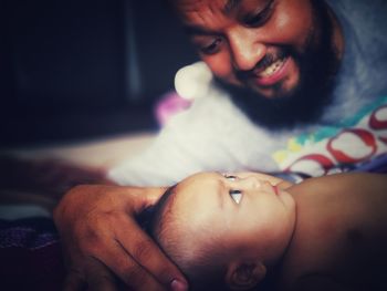 Man looking at baby boy on bed