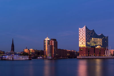 Illuminated buildings in city at waterfront