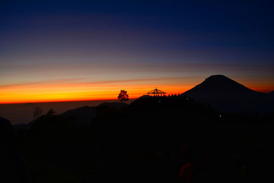 Scenic view of silhouette mountains against sky during sunset