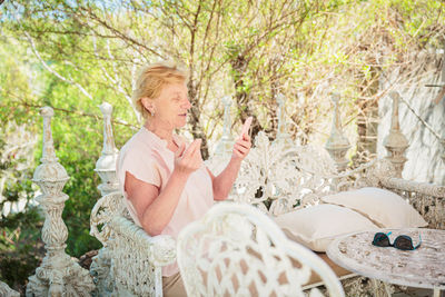 Mature attractive woman traveler sitting alone on the terrace of coffee shop