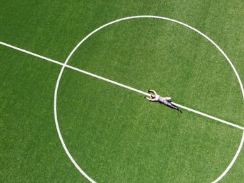 Aerial view of woman lying down football field