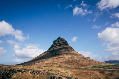Low angle view of kirkjufell against blue sky