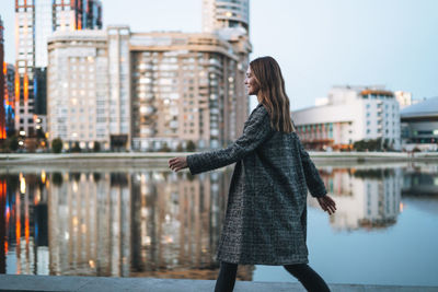 Rear view of woman standing against buildings