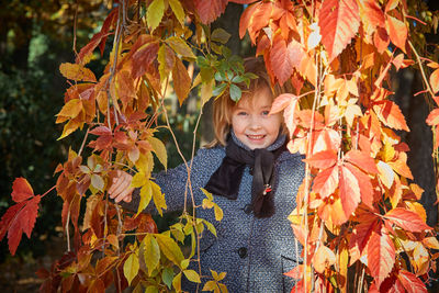 Portrait of smiling girl with autumn leaves