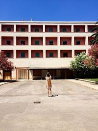 Full length of a man with dog walking in front of building