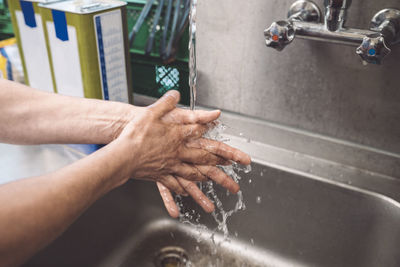 Cropped image of chef washing hands in commercial kitchen