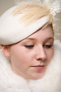 Close-up of young woman looking away against wall