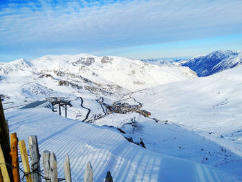 Aerial view of snowcapped mountains against blue sky