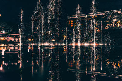 Illuminated fountain in city at night