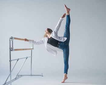 Caucasian woman posing at the ballet barre. 