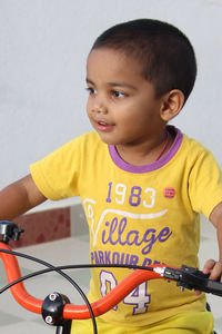Cute smiling boy on bicycle at home