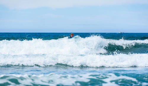 Man surfing in sea against sky