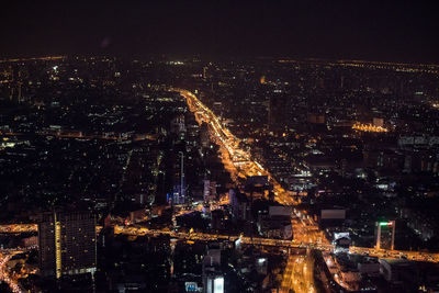 High angle view of illuminated city against sky at night