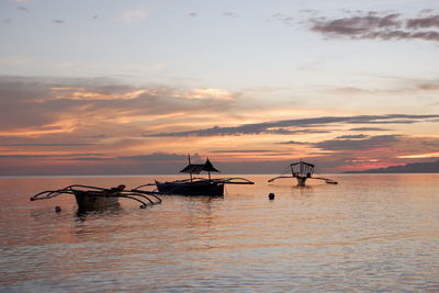 Silhouette ship in sea against sky during sunset