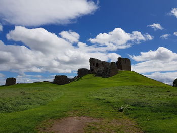 Scenic view of field against cloudy sky