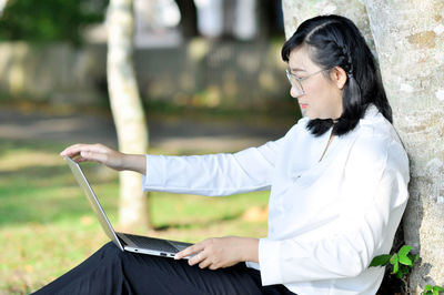 Young woman looking at camera while sitting outdoors