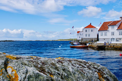 Scenic view of sea by buildings against sky