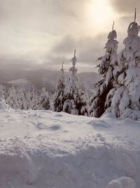 Snow covered landscape against sky