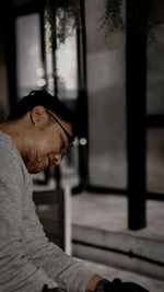 Side view of young man looking at camera