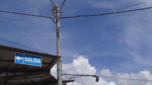 Low angle view of information sign against sky