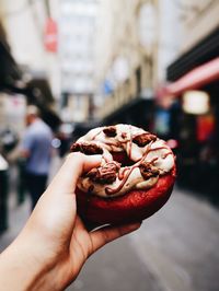 Midsection of person holding ice cream in city