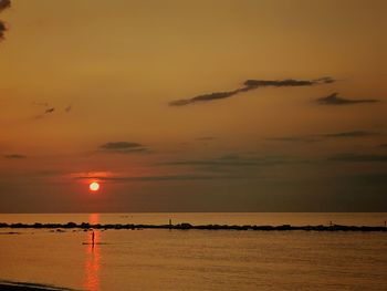 Scenic view of sea against orange sky