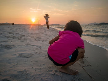 Rear view of women on beach during sunset