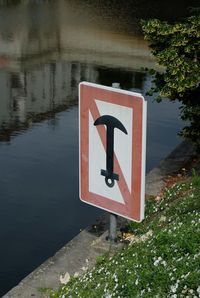 Close-up of road sign by lake