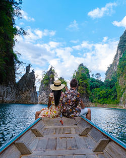 Rear view of woman sitting on boat in sea