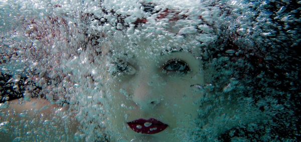 Close-up portrait of woman swimming in sea