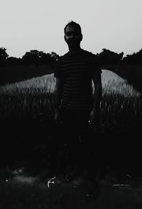 Man standing on field against clear sky