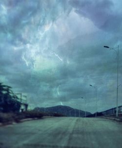 Empty road against cloudy sky