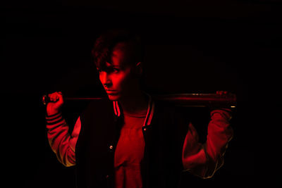 Portrait of young man with red hair against black background