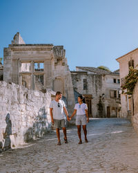 Friends standing at historical building against clear sky
