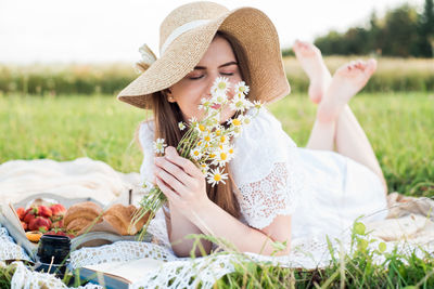 Midsection of woman sitting on grassy field