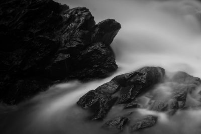 View of rock formation in water against sky