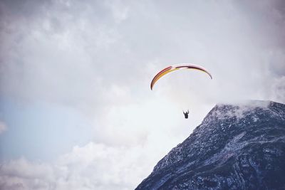 Low angle view of people paragliding