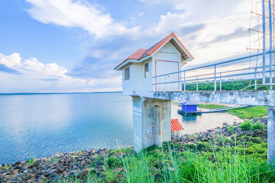 House on beach by sea against sky