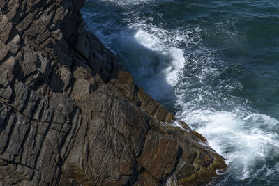 High angle view of waves breaking on rocks