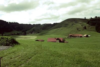 Scenic view of grassy field against cloudy sky