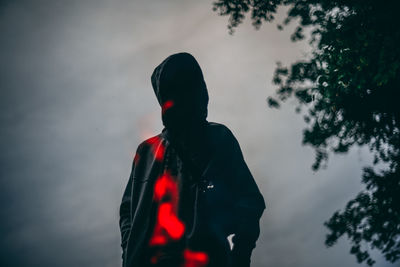 Rear view of silhouette man standing against sky