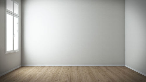 Empty wooden floor against wall at home