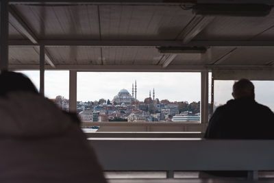Rear view of man looking through window