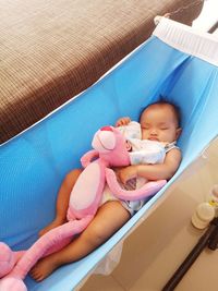 High angle view of cute baby girl sleeping in hammock at home