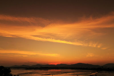 Scenic view of sea against dramatic sky during sunset