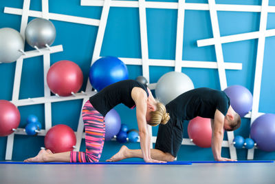 Side view of man and woman exercising in health club